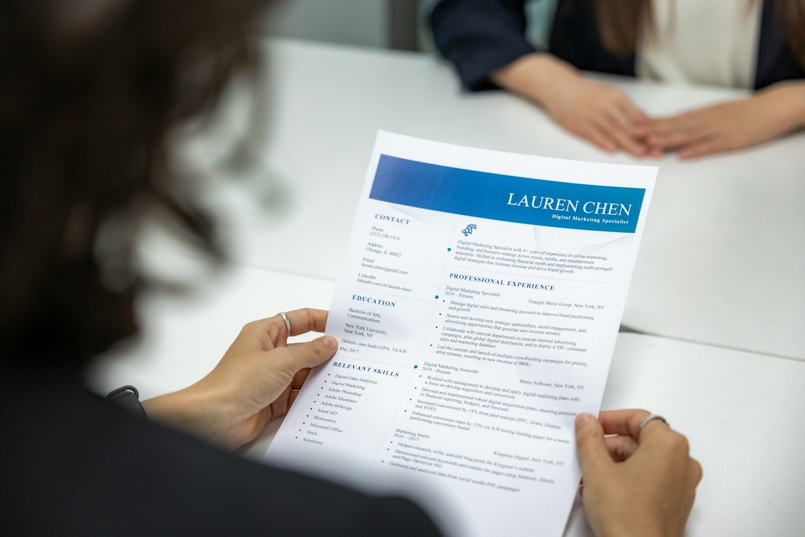 Woman reading a resume at a table, illustrating AI help for job seekers