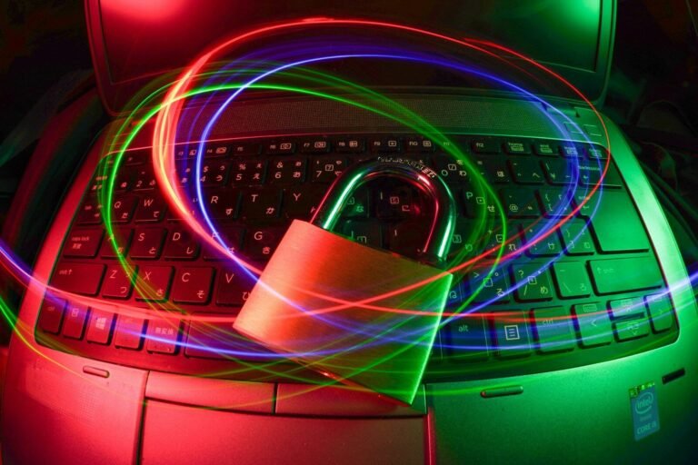 Padlock on a laptop keyboard surrounded by glowing light trails, illustrating passwords and two-factor authentication for securing online accounts
